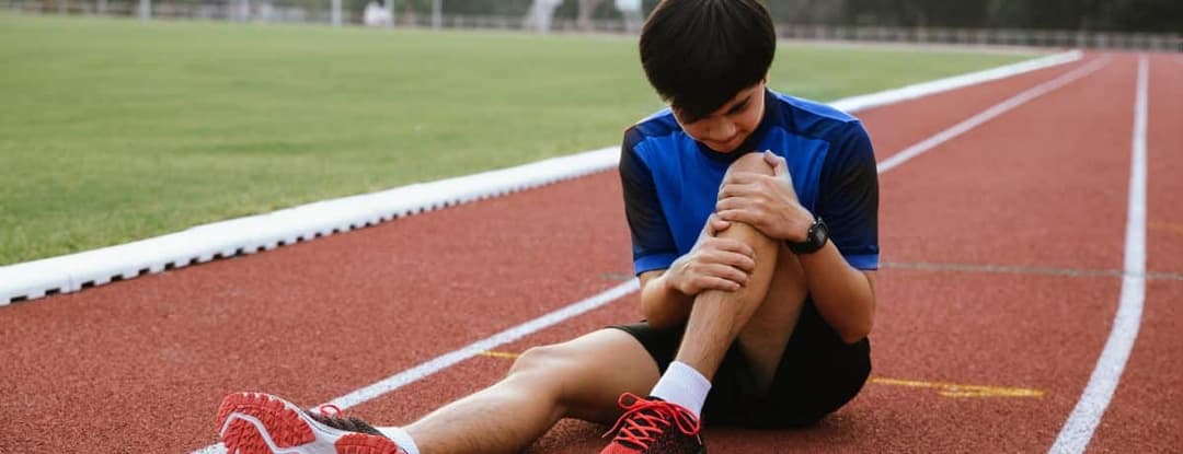injured runner holding knee