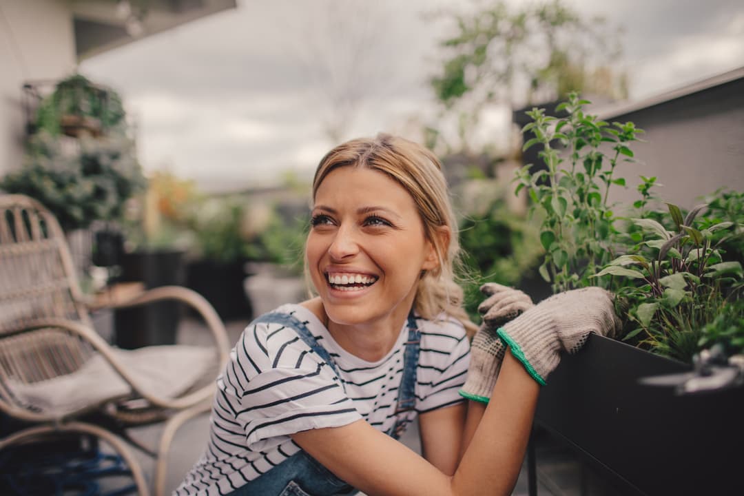 young woman tending her porch farm